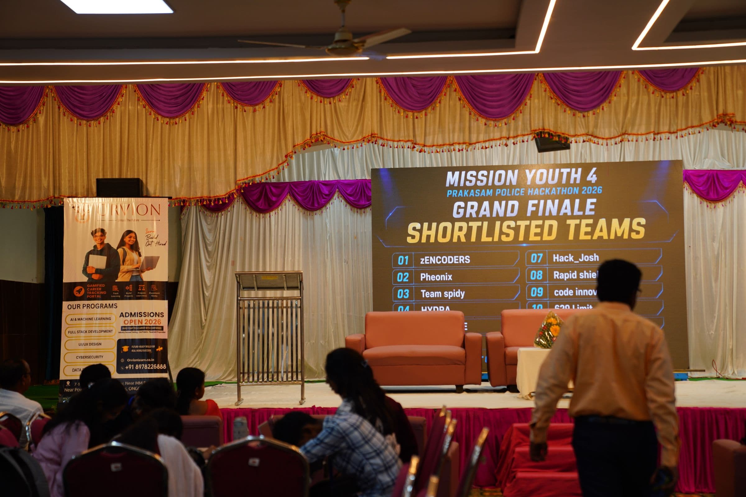 Hackathon audience and stage backdrop for Mission Youth 4, presented by Orvion, Prakasam Police, and Sraventix Technologies