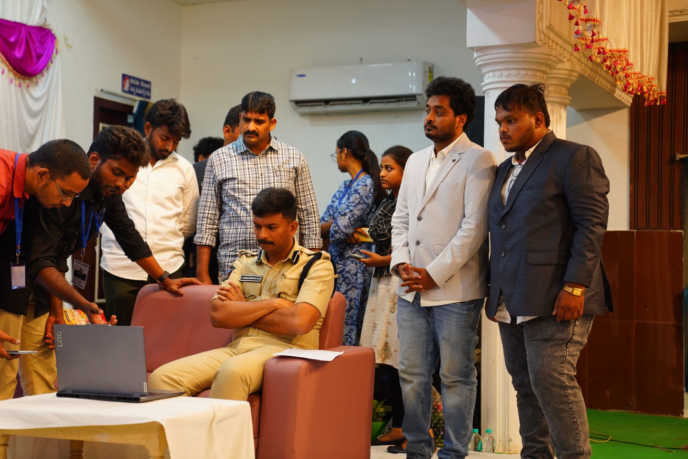 A senior Prakasam Police officer reviewing a student team's project on stage