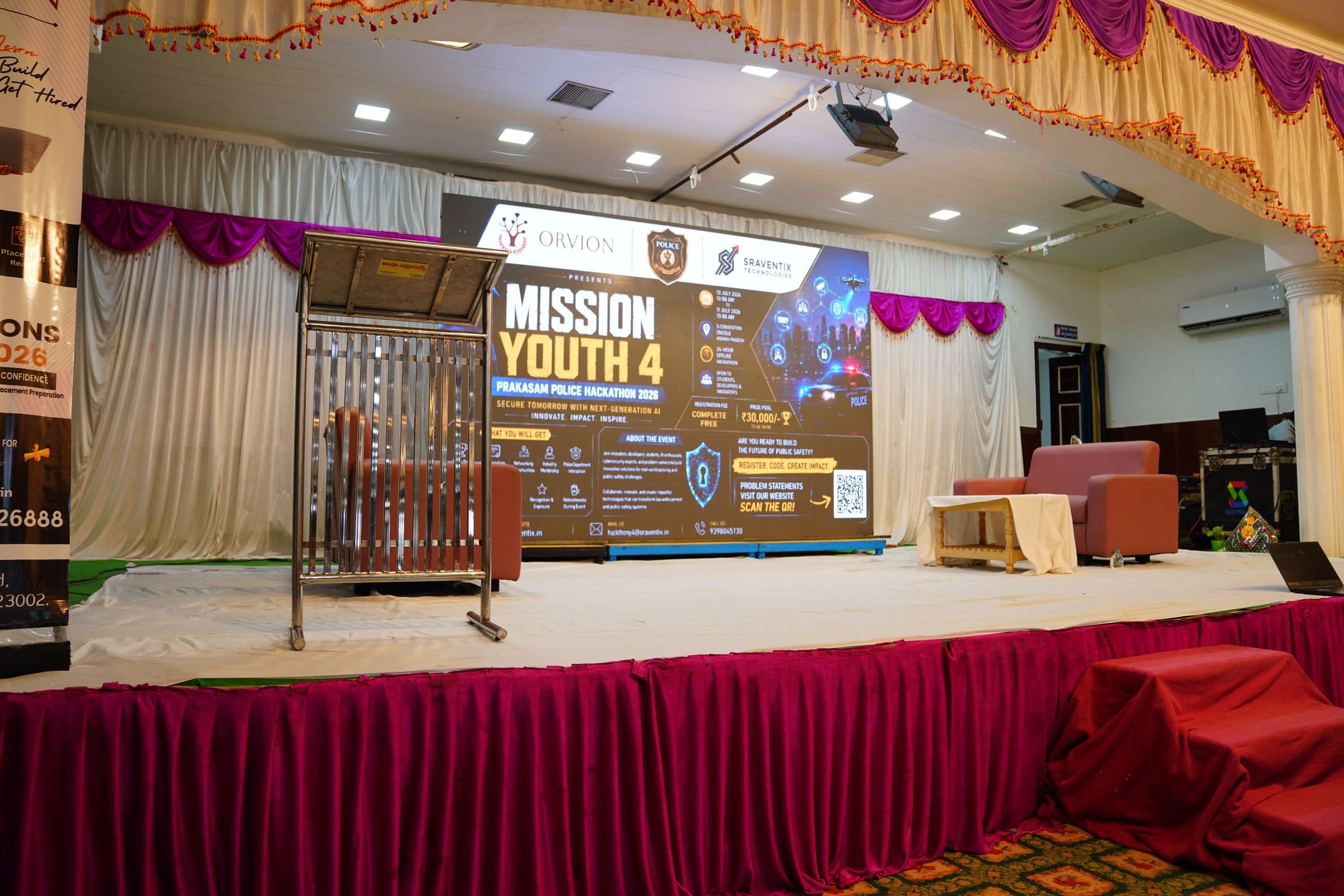 The Mission Youth 4 hackathon stage set before the event begins, backed by the Orvion, Prakasam Police, and Sraventix Technologies banner
